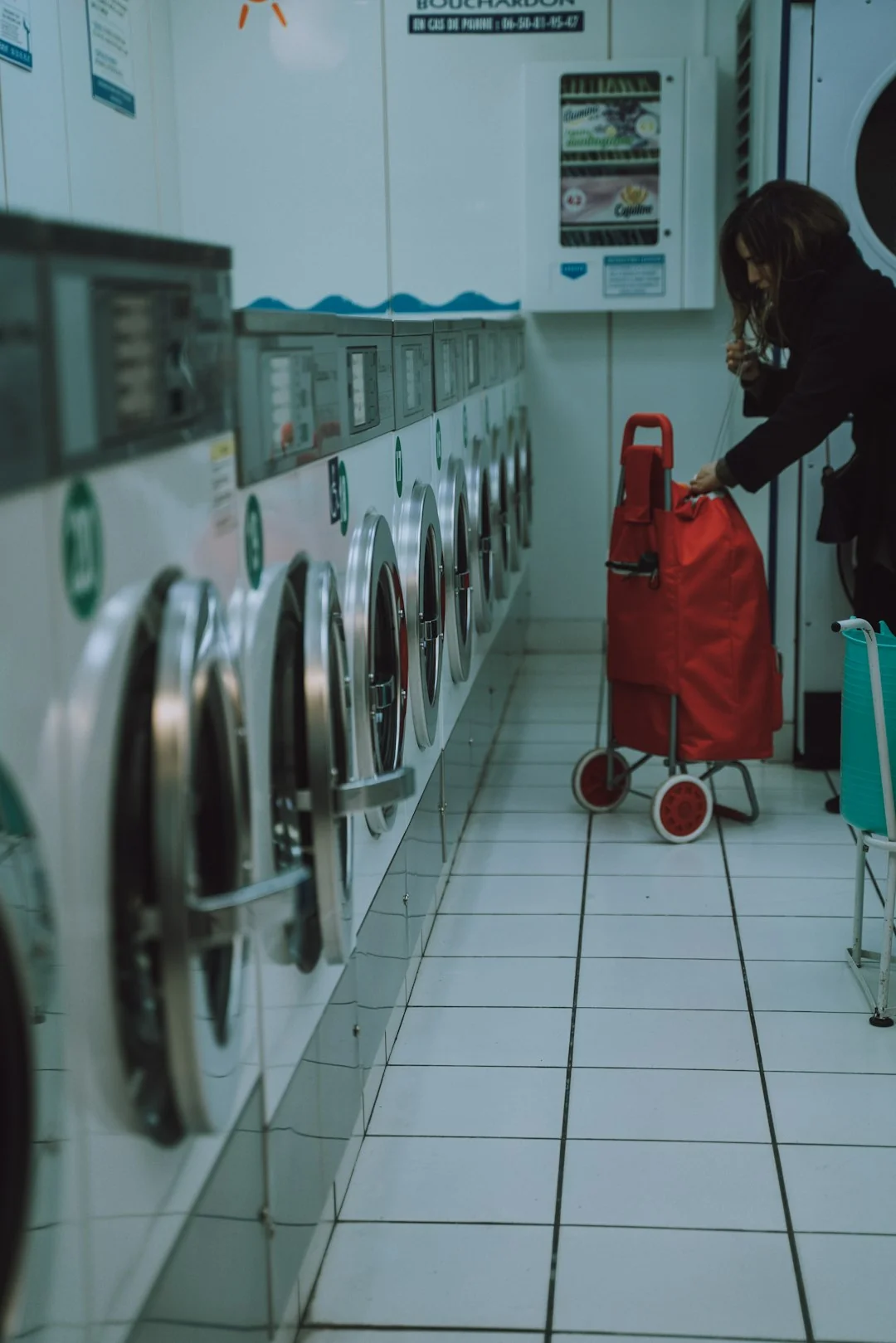 A team of professional cleaners dressed in red uniforms is using a vacuum cleaner indoors.